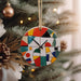 a colorful clock hanging from a christmas tree