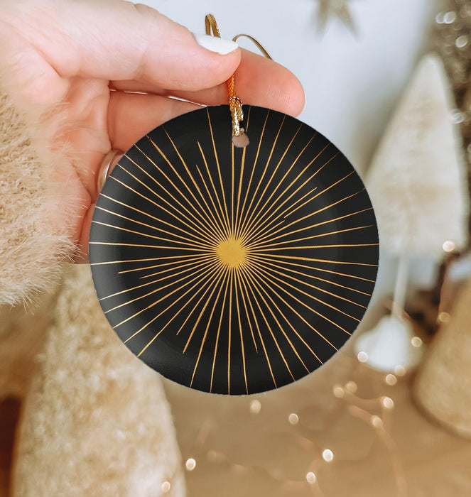 a person holding a black and gold ornament