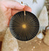 a person holding a black and gold ornament