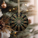 a black and gold ornament hanging from a christmas tree