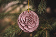 a pink ornament hanging from a pine tree