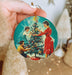 a person holding a christmas ornament in their hand