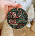 a person holding a christmas ornament in their hand