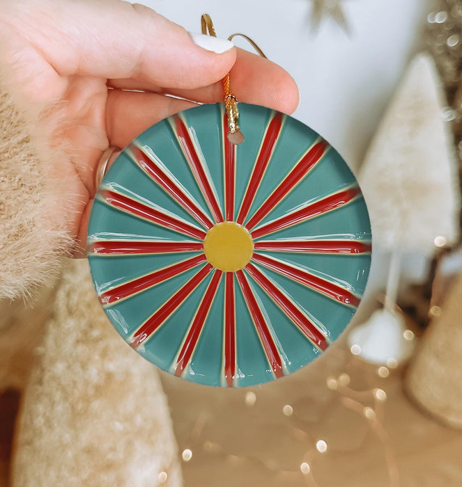 a person holding a christmas ornament in their hand