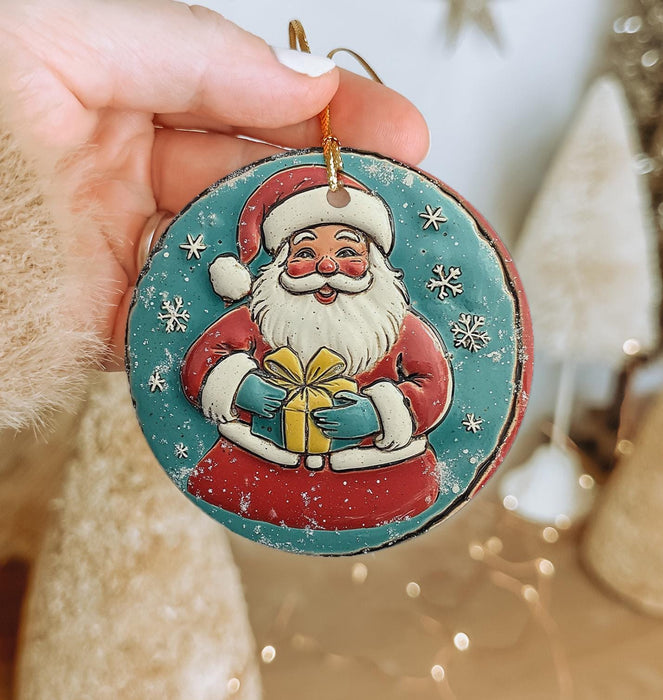 a hand holding a christmas ornament with a santa clause on it