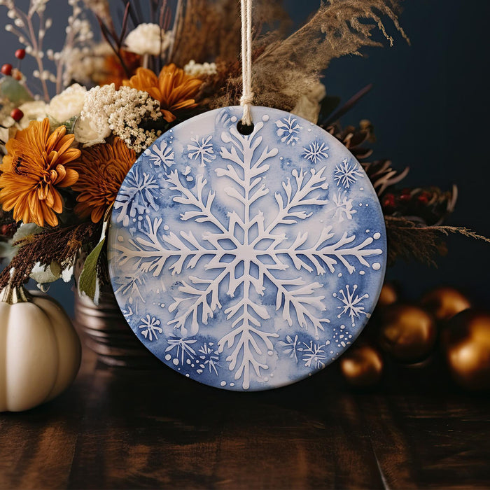 a blue and white snowflake ornament sitting on a table next to