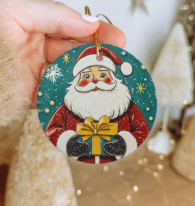 a hand holding a christmas ornament with a santa clause on it
