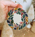 a person holding a christmas ornament in their hand
