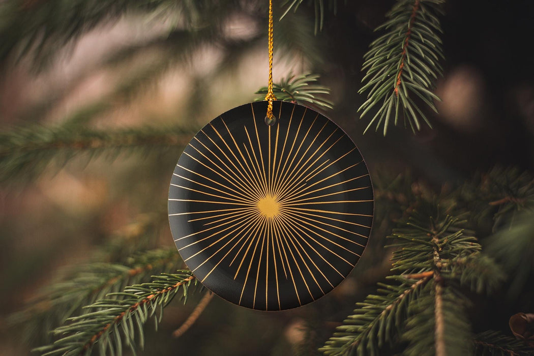 a black ornament hanging from a pine tree