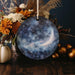 a ceramic ornament with a picture of the moon on it