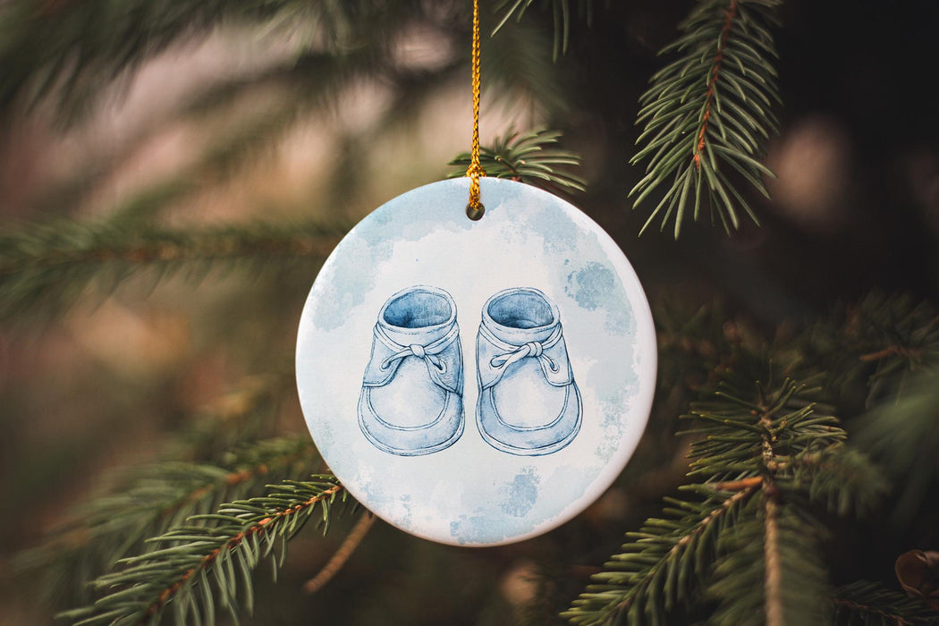 a ceramic ornament with a pair of baby's shoes hanging from a