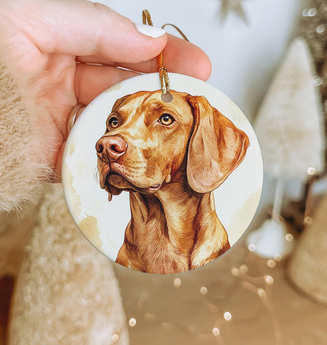 a hand holding a christmas ornament with a picture of a dog