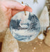 a person holding a christmas ornament in their hand