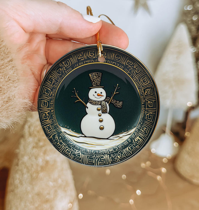 a person holding a christmas ornament with a snowman on it