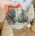 a person holding a christmas ornament in their hand
