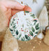 a person holding a christmas ornament in their hand
