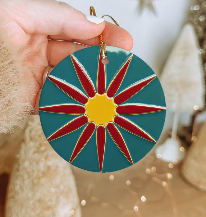 a person holding a christmas ornament in their hand