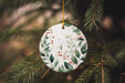 a ceramic ornament hanging from a christmas tree