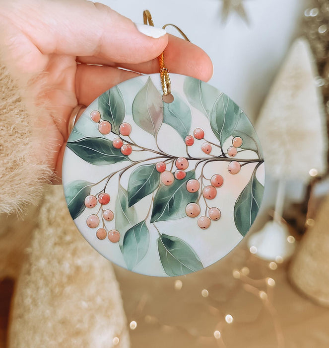 a hand holding a ceramic ornament with berries on it