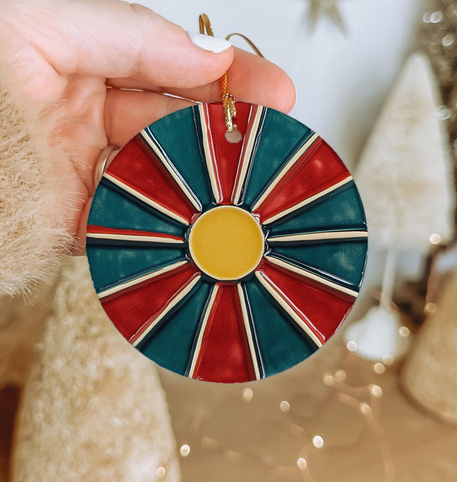 a person holding a christmas ornament in their hand