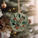 a ceramic ornament hanging from a christmas tree