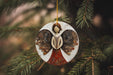 a ceramic angel ornament hanging from a christmas tree