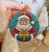 a person holding a christmas ornament in their hand