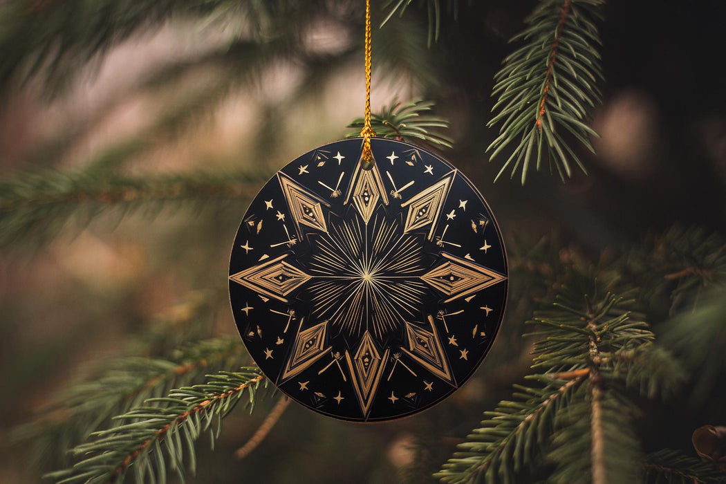 a black and gold ornament hanging from a tree