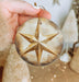a person holding a christmas ornament in their hand