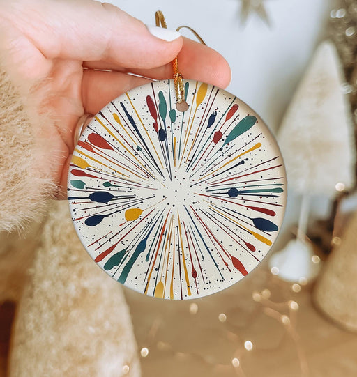 a hand holding a christmas ornament with a design on it