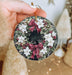a hand holding a christmas ornament with a bow