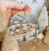 a person holding a christmas ornament in their hand