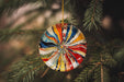 a colorful ornament hanging from a tree