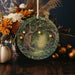 a plate with a picture of a tree surrounded by pumpkins and flowers
