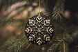 a snowflake ornament hanging from a christmas tree
