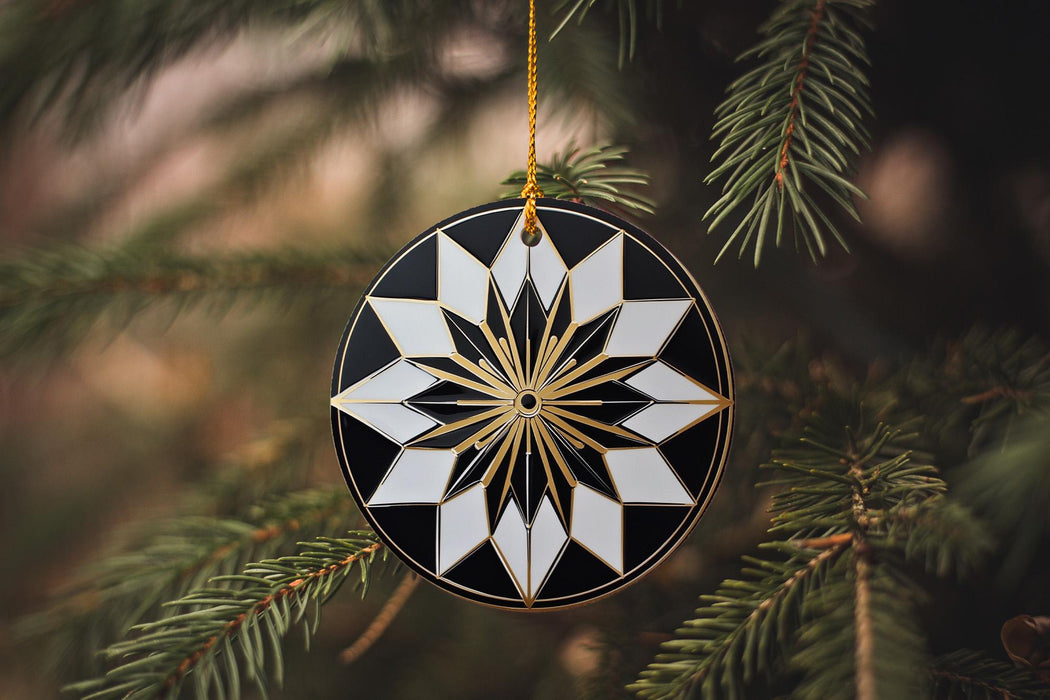 a black and white ornament hanging from a christmas tree