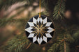 a black and white ornament hanging from a christmas tree