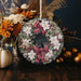 a christmas ornament decorated with flowers and a bow