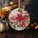 a ceramic ornament decorated with poinsettis and flowers