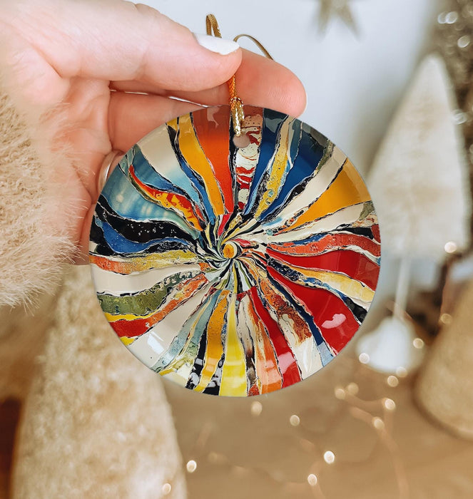 a person holding a colorful glass ornament in their hand
