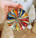 a person holding a colorful glass ornament in their hand