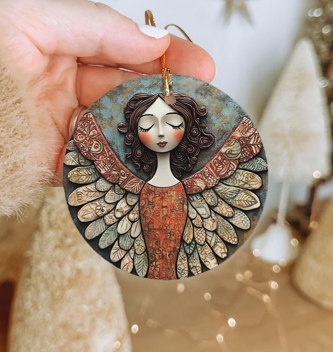 a hand holding a ceramic angel ornament