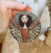 a hand holding a ceramic angel ornament