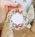 a person holding a christmas ornament in their hand