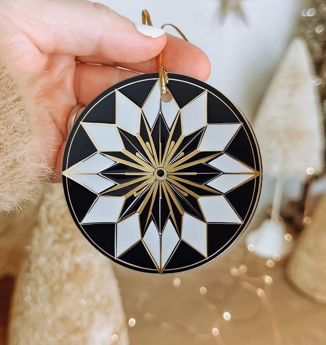 a hand holding a black and white ornament