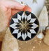 a hand holding a black and white ornament