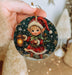 a person holding a christmas ornament in their hand