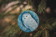 a ceramic owl ornament hanging from a christmas tree