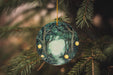 a glass ornament hanging from a christmas tree