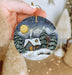 a person holding a christmas ornament in their hand